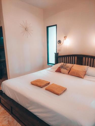 a bedroom with a large white bed with two towels on it at Naraya Resort in Ko Lanta