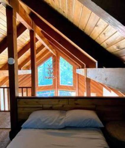 a bed in a room with a loft at Pinecrest A-Frame Family fun near Dodge Ridge in Long Barn
