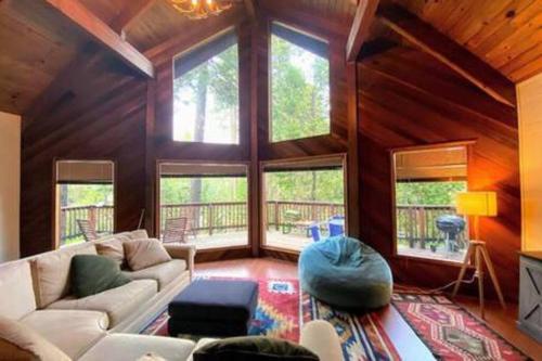 a living room with a white couch and some windows at Pinecrest A-Frame Family fun near Dodge Ridge in Long Barn