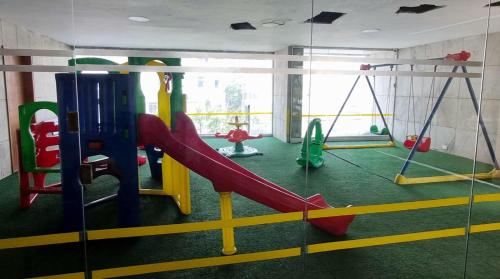 a play room with a slide and swings at Apart Hotel Copacabana in Rio de Janeiro