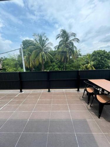 a patio with tables and benches and palm trees at Minimalist Heaven Near Tmn Intan in Sungai Petani