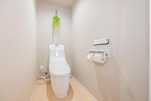 ein Badezimmer mit einem WC und einer Pflanze an der Wand in der Unterkunft 田端精装套房 403 in Tokio