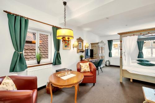 a living room with a bed and a table at Artistique Hotel in Dinkelsbühl