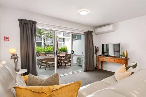 a living room with a white couch and a table at Warm and inviting - Free carpark in Christchurch