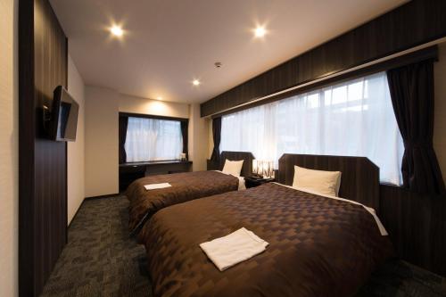 Postel nebo postele na pokoji v ubytování Hotel Taisei Nakanoshima