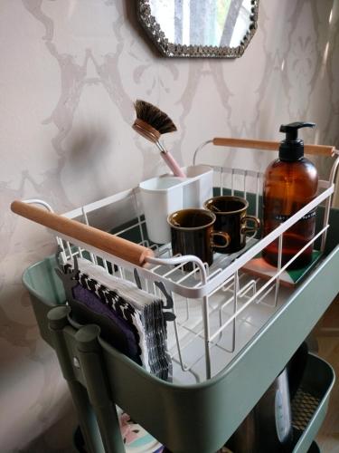 a shelf in a bathroom with cups and brushes at Viinikan Tähti lemmikkiystävällinen kotimajoitus in Tampere