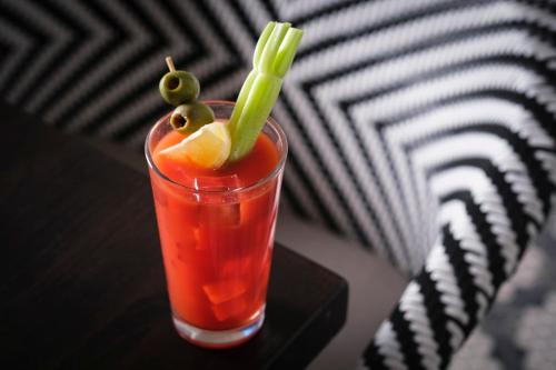 a drink sitting on a table with a green garnishment at Kimpton - Grand Roatan Resort and Spa in West Bay