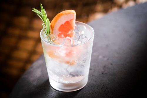 a glass of water with an orange slice on a table at Kimpton - Grand Roatan Resort and Spa in West Bay
