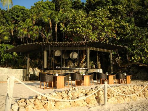 a group of chairs and a table on the beach at Kimpton - Grand Roatan Resort and Spa in West Bay