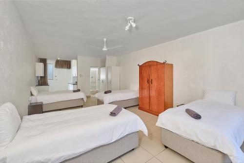 a bedroom with two beds and a bathroom at Inn & Out Sandton Park in Johannesburg
