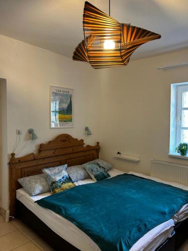 a bedroom with a large bed with blue sheets at Palócliget Vendégház in Kétbodony