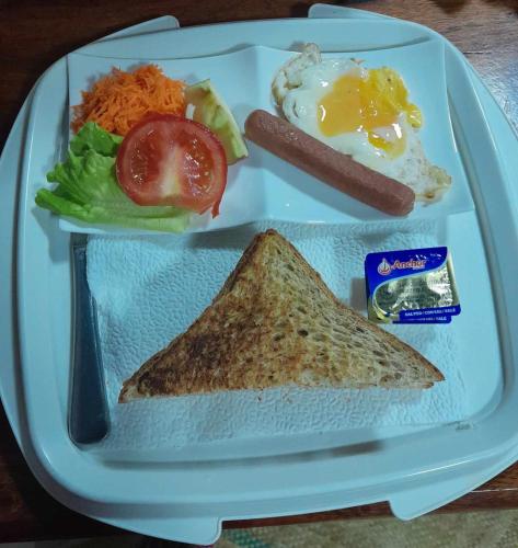 a plate of food with an egg and a sandwich at Fitz & Oritz Homestay in Nanguilé