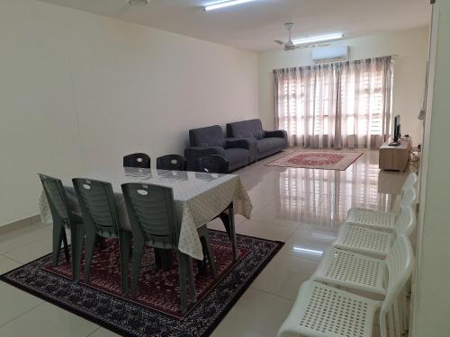 a living room with a table and chairs and a couch at Abie's Homestay Putrajaya in Putrajaya