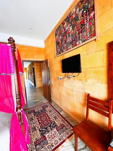 a living room with a tv on a wall at Hotel Royal Heritage in Jaisalmer