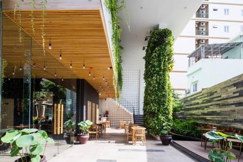an outdoor patio with tables and chairs and plants at Babylon Garden Da Nang in Da Nang