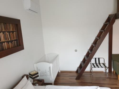 a room with a staircase with a bed and a chair at Aranydukát Vendégház Tállya in Tállya