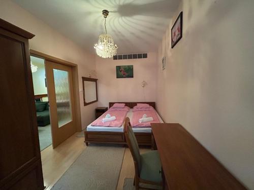 sypialnia z łóżkiem, stołem i żyrandolem w obiekcie Rehab Apartment VIP w Hévízie