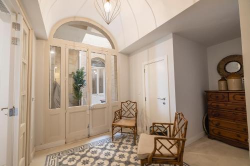 a hallway with two chairs and a door at Harbour Mansion in Birgu