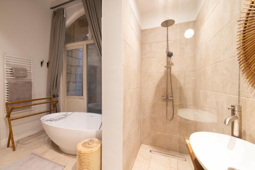 a bathroom with a bath tub and a sink at Harbour Mansion in Birgu