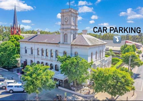a large white building with a clock tower on top of it at Clocktower Suites in Echuca