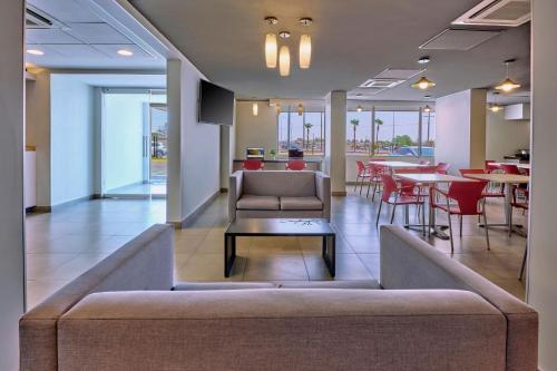 a lobby with a couch and tables and chairs at City Express Junior by Marriott Mexicali in Mexicali