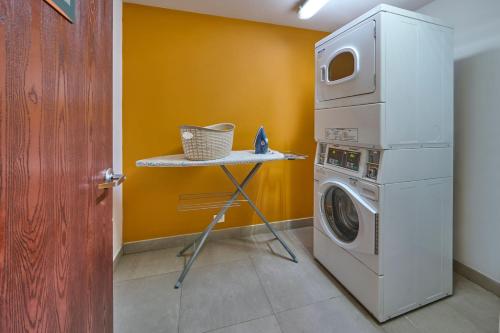 a laundry room with a washing machine and a table at City Express Junior by Marriott Mexicali in Mexicali