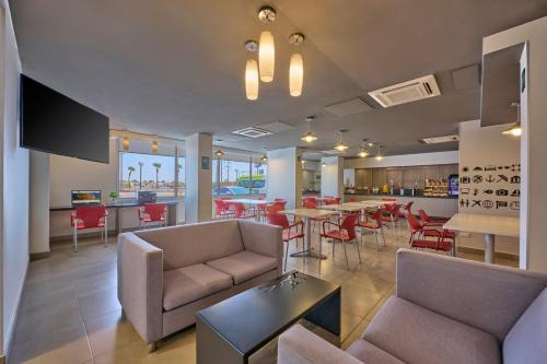 a lobby with chairs and tables and a bar at City Express Junior by Marriott Mexicali in Mexicali