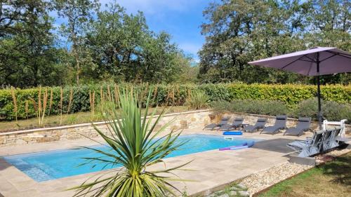 une piscine avec des chaises et un parasol dans l'établissement Pech Joli, à La Dornac
