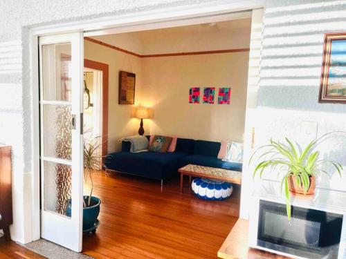 a living room with a blue couch and a table at Church Street Shop Top in Bellingen