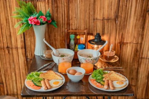 Ban Thung Phan Haม่อนสาเคียงดาว的一张桌子,上面放着两盘食物,鸡蛋和绿叶