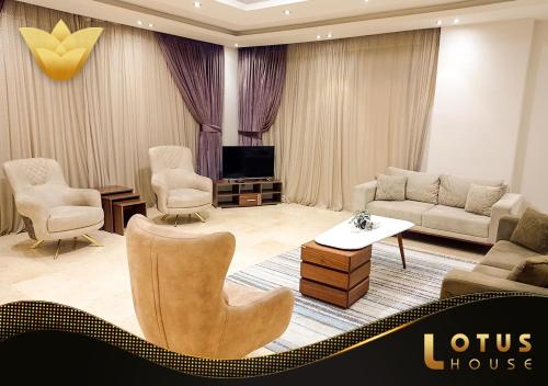 a living room with a couch and chairs and a tv at El Lotus Building in Cairo