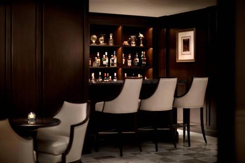 a bar with a bunch of white chairs in a room at The Ritz-Carlton Osaka in Osaka