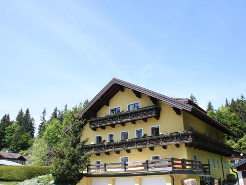 ein gelbes Gebäude mit braunem Dach in der Unterkunft Luxurious Apartment in Krispl Salzburg with swimming pool in Krispl