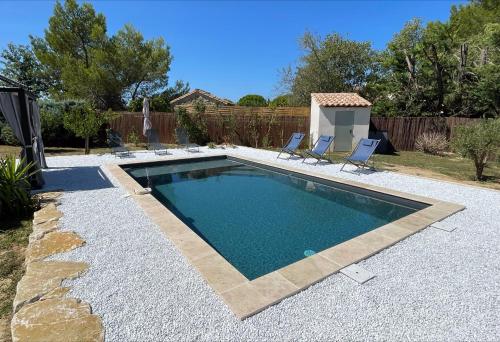 une piscine avec deux chaises longues à côté dans l'établissement L'Eden à Blauzac, à Blauzac