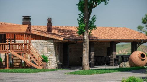 a house with a wooden deck and a building at Chateau Mephis Kalaki in Akhalkʼalakʼi