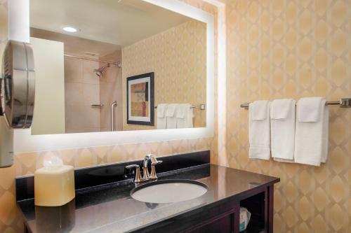 a bathroom with a sink and a mirror and towels at Crowne Plaza Hotel St. Louis Airport by IHG in Bridgeton