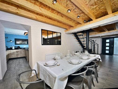 une salle à manger avec une table et des chaises blanches dans l'établissement Gîte moderne au calme - Tout confort - Jolie vue, à Lugagnan