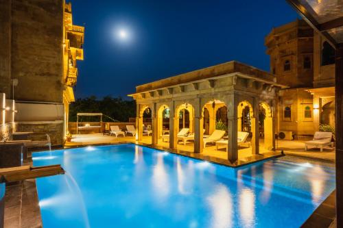 an outdoor pool with a gazebo at night at The Gulaal in Jaisalmer