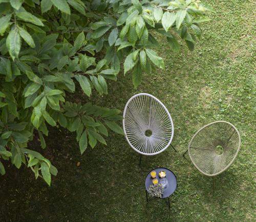 an overhead view of three chairs and a table at LUZ 03 room in Bologna