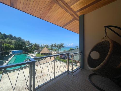 a balcony with a hammock and a view of the ocean at Kai Bae Beach Resort Koh Chang in Ko Chang