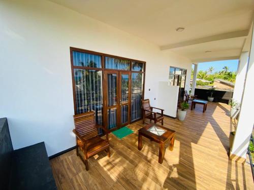 a living room with chairs and a table at The Wave's Guest House in Mirissa