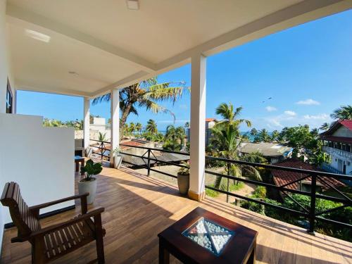 a balcony with a bench and a view of the ocean at The Wave's Guest House in Mirissa
