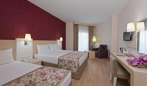 Una habitación de hotel con dos camas y un escritorio. en Side Lilyum Hotel & Spa, en Side