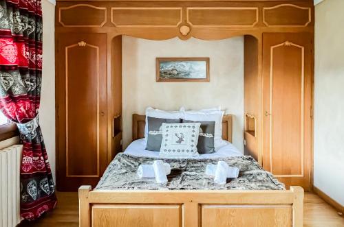 une chambre avec un lit avec une tête de lit en bois dans l'établissement Chalet Orchidee Megeve sur les pistes, à Megève