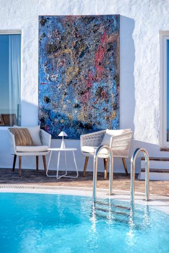 a pool with two chairs and a painting on the wall at Casa Serena 10 Boutique- Adults Only-Breakfast Included in Mácher