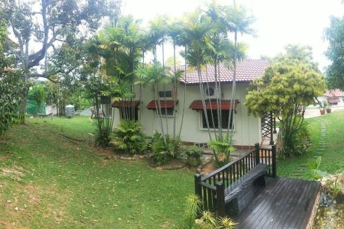 a house with a wooden deck in a yard at Pet-Friendly, Spacious Family Cottage, with Games Lounge & Near Beach in Port Dickson