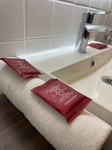 - une salle de bains avec 2 oreillers rouges sur un comptoir dans l'établissement My Cosy Green, Appartement Stylé et proche des commodités, à Nevers