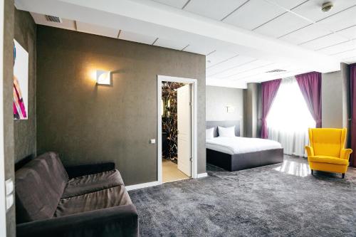 a hotel room with a bed and a couch at Business Hotel Conference Center & Spa in Târgu-Mureş