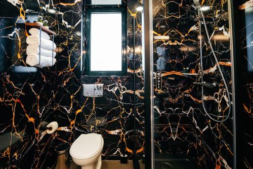 a bathroom with a black and gold wall at Business Hotel Conference Center & Spa in Târgu-Mureş