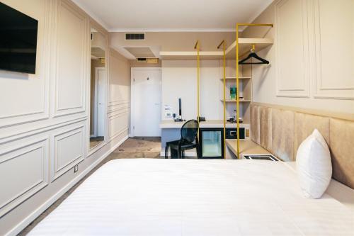 a bedroom with a white bed and a desk at Business Hotel Conference Center & Spa in Târgu-Mureş